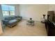 Modern living room featuring a plush grey couch and tile flooring at 5054 Tibet Ct, St Cloud, FL 34772