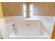 A close up shot of a bathtub featuring tiled walls, bright light and updated fixtures at 508 W Plantation Blvd, Lake Mary, FL 32746