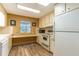 Cozy kitchen featuring vintage cabinets, appliances, and a built-in desk area, ideal for casual dining or workspace at 508 W Plantation Blvd, Lake Mary, FL 32746