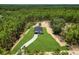 Aerial view of a home with a long driveway, surrounded by lush greenery and forest at 6106 Sw 127 Avenue Rd, Ocala, FL 34481