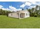 Rear view of a white home featuring a covered patio and well maintained lawn at 6106 Sw 127 Avenue Rd, Ocala, FL 34481
