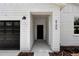 Inviting front entrance featuring a modern front door, dark garage door, and house number 6106 at 6106 Sw 127 Avenue Rd, Ocala, FL 34481