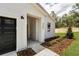 Inviting entrance with a black garage door, stylish house number, and fresh landscaping at 6106 Sw 127 Avenue Rd, Ocala, FL 34481