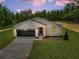 Beautiful home with dark garage door, front yard, and manicured landscaping at 6106 Sw 127 Avenue Rd, Ocala, FL 34481