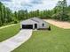 A modern house featuring a large garage, paved driveway, and well-manicured front lawn at 6106 Sw 127 Avenue Rd, Ocala, FL 34481