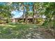 Spacious backyard with lawn and view of patio and sunroom under mature trees at 626 Pearl Rd, Winter Springs, FL 32708
