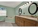 Bright bathroom features a dual sink vanity, granite countertop, an arched window and soaking tub at 626 Pearl Rd, Winter Springs, FL 32708