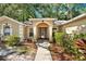 Inviting front entrance with an arched portico, columns, and a glass paneled front door at 626 Pearl Rd, Winter Springs, FL 32708
