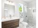 Bright bathroom features a modern vanity and glass enclosed shower with marble surround at 7065 Branch Court, St Cloud, FL 34771