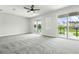 Large bedroom with balcony, gray carpet, and natural light at 7065 Branch Court, St Cloud, FL 34771