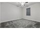 Bedroom with neutral gray walls and carpet, featuring a ceiling fan and large window at 7065 Branch Court, St Cloud, FL 34771