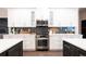 Modern kitchen features stainless steel appliances, white cabinets, and a sleek backsplash at 7065 Branch Court, St Cloud, FL 34771