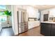 Modern kitchen with stainless steel refrigerator, wine rack, white cabinetry, and dark hardwood floors at 7065 Branch Court, St Cloud, FL 34771