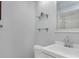 Bathroom with white walls and glass shelving above a toilet, and a sink vanity with a chrome faucet at 7858 Sugar View Ct # 7858, Orlando, FL 32819