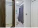 Neutral bathroom with an enclosed toilet area and walk-in shower behind a white closet and a wood-framed mirror at 7858 Sugar View Ct # 7858, Orlando, FL 32819