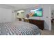 Cozy bedroom with a large TV, dresser, vanity and desert-themed blanket at 7858 Sugar View Ct # 7858, Orlando, FL 32819