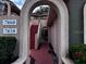 View of building entrance with an arched walkway and red stairs leading to the upper units at 7858 Sugar View Ct # 7858, Orlando, FL 32819