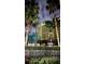 Tall building featuring a unique design, framed by palm trees against a twilight sky at 8125 Resort Village Dr # 5808, Orlando, FL 32821