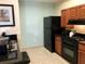 Kitchen with black appliances, wooden cabinets, and granite countertops offers a modern and functional space at 8125 Resort Village Dr # 5808, Orlando, FL 32821