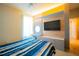 Bedroom with TV, vanity area and storage, decorative wainscoting, and large window for natural light at 8137 Pond Apple Dr, Winter Garden, FL 34787