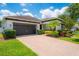 Charming single-story home with a well-manicured lawn, mature landscaping, and a brick paver driveway at 8137 Pond Apple Dr, Winter Garden, FL 34787