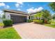 Charming single-story home with a well-manicured lawn, mature landscaping, and a brick paver driveway at 8137 Pond Apple Dr, Winter Garden, FL 34787