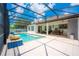 Outdoor entertaining poolside under a screened lanai with beautiful blue sky at 8137 Pond Apple Dr, Winter Garden, FL 34787