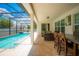 Screened in pool with patio seating and outdoor dining area under a blue sky at 8137 Pond Apple Dr, Winter Garden, FL 34787
