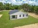 Aerial view of a newly constructed single-story home featuring a dark roof and a spacious backyard at 8258 Sw 136Th Ter, Dunnellon, FL 34432