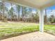 Spacious backyard with lush green grass, mature trees, and a covered patio with a concrete foundation at 8258 Sw 136Th Ter, Dunnellon, FL 34432