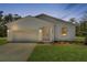 A lovely one-story white home featuring a two-car garage, verdant lawn, and eye-catching curb appeal at 8258 Sw 136Th Ter, Dunnellon, FL 34432
