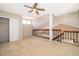 Spacious loft area with carpet, railing overlooking stairs, and a ceiling fan at 849 Millrace Pt, Longwood, FL 32750