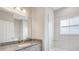 Bright bathroom featuring granite counters, gray cabinetry, and a tiled shower and tub at 8560 Magnificent Ln, Groveland, FL 34736