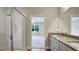 Modern main bathroom with marble tile shower, granite vanity with double sinks, and door to bedroom at 8560 Magnificent Ln, Groveland, FL 34736