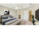 Spacious main bedroom featuring a tray ceiling, fan, and ensuite bathroom, creating a luxurious retreat at 8560 Magnificent Ln, Groveland, FL 34736