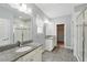 Bright bathroom featuring double sinks with granite countertops, walk-in shower, and walk-in closet at 9389 Meadow Hunt Way, Winter Garden, FL 34787