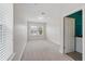 Bright bedroom featuring neutral carpet, double windows, and a glimpse into the laundry room at 9389 Meadow Hunt Way, Winter Garden, FL 34787