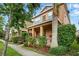 Inviting two-story home with a covered porch and lush tropical landscaping at 9389 Meadow Hunt Way, Winter Garden, FL 34787