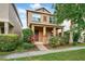 Charming two-story home with a covered front porch and mature landscaping at 9389 Meadow Hunt Way, Winter Garden, FL 34787