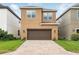 Two-story home with a paved driveway, a two-car garage, and attractive landscaping at 9389 Meadow Hunt Way, Winter Garden, FL 34787