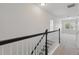 Upstairs hallway with neutral carpet, white walls, and stairway at 9389 Meadow Hunt Way, Winter Garden, FL 34787