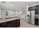 Kitchen features stainless appliances, dark cabinets and granite countertops; opens to living room at 9389 Meadow Hunt Way, Winter Garden, FL 34787