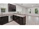 Modern kitchen with granite countertops, stainless steel dishwasher, and dark wood cabinets with wine rack at 9389 Meadow Hunt Way, Winter Garden, FL 34787