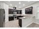 Modern kitchen featuring stainless steel appliances, dark wood cabinets, and stone countertops at 9389 Meadow Hunt Way, Winter Garden, FL 34787