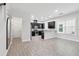 Modern open floor plan with wood-style tile, dark cabinetry, and ample natural light at 9389 Meadow Hunt Way, Winter Garden, FL 34787