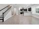 Spacious living room featuring modern flooring, staircase, and a seamless transition to the adjacent kitchen at 9389 Meadow Hunt Way, Winter Garden, FL 34787