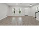 Spacious living room with wood-style floors, bright natural light, and a classic staircase at 9389 Meadow Hunt Way, Winter Garden, FL 34787