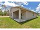 Back patio view of single-story home with a covered back porch and lawn at 9695 Sw 125 Court Rd, Dunnellon, FL 34432