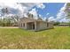 Backyard view of a single-story home with a covered back porch and a spacious yard at 9695 Sw 125 Court Rd, Dunnellon, FL 34432