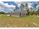 Backyard view of single-story home with a covered back porch and green lawn at 9695 Sw 125 Court Rd, Dunnellon, FL 34432